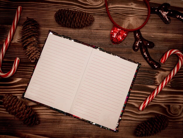 Zdjęcie pusty notatnik do rekordów życzeń mikołajów na drewnianym tle ujawnione strony pamiętnika