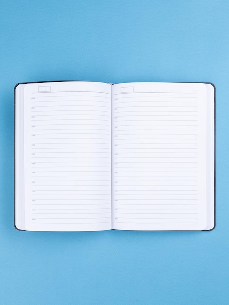 Pusty otwarty notebook na niebieskim tle zbliżenie Koncepcja projektowania