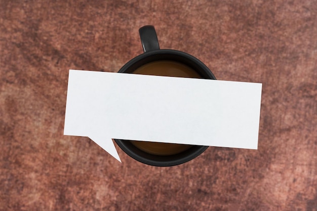 Pusty papier bąbelkowy myśli na filiżance kawy na drewnianym tle pusty arkusz umieszczony nad kubkiem