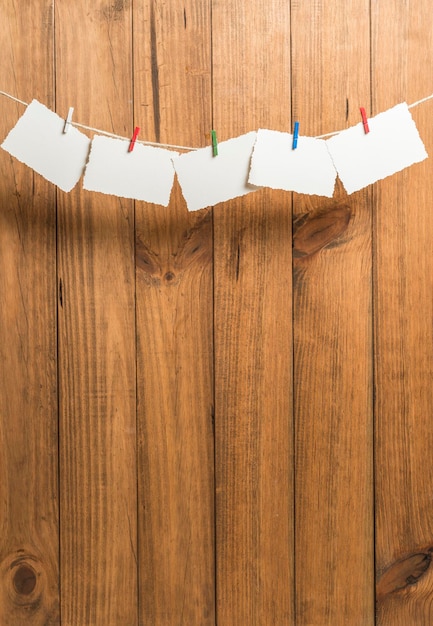 Zdjęcie pusty papier wiszący na sznurku do ubrań na drewnianej ścianie