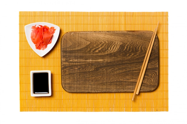 Pusty prostokątny brązowy drewniany talerz z pałeczkami do sushi