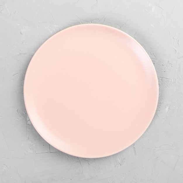 Zdjęcie pusty różowy okrągły talerz na drewnianym stole