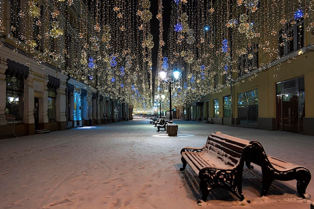 Pusty sklep na zimowej ulicy noworocznej ozdobionej girlandami i lampionami bez ludzi Noworoczne zdjęcia miejskiego oświetlenia ulicznego