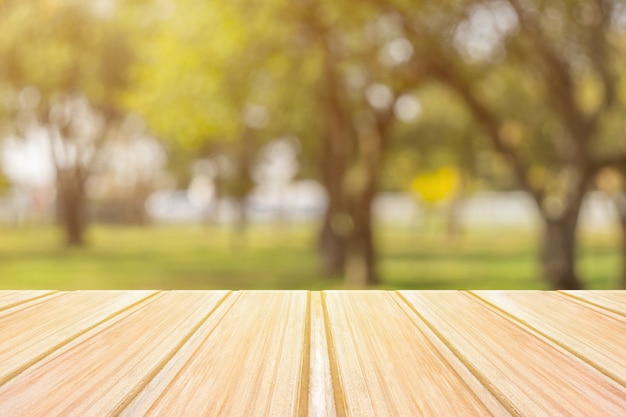 Zdjęcie pusty żółty drewniany stół z zamazanym miasto parkiem