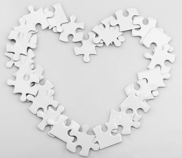 Zdjęcie puzzle w kształcie serca na szarym tle