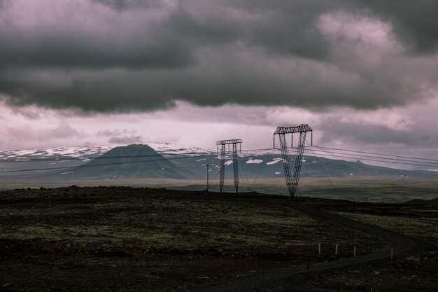 Zdjęcie pylon elektryczny na polu przeciwko niebu