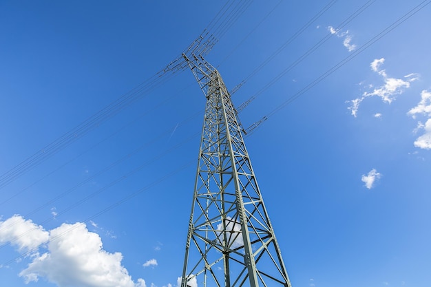 Pylon energetyczny na niebieskim zachmurzonym niebie przemysł wysokiego napięcia