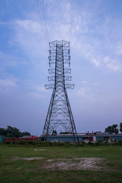 Pylon wysokiego napięcia pod zachmurzonym błękitnym niebem