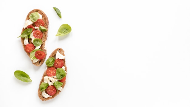 Pyszna bruschetta z liśćmi bazylii na białej powierzchni