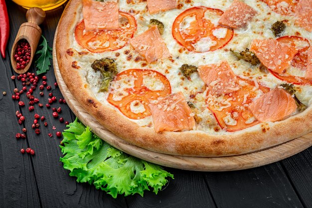 Pyszna gorąca pizza z pomidorami łososiowymi i różnymi przyprawami