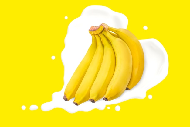 Pyszna kiść bananów z mlekiem w kształcie serca na żółtym tle