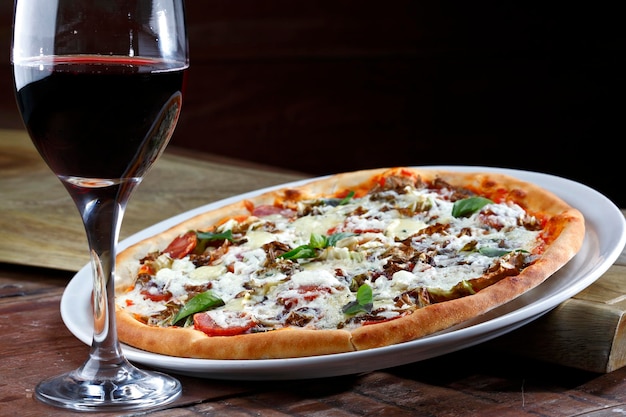 Pyszna włoska pizza z kieliszkiem do czerwonego wina