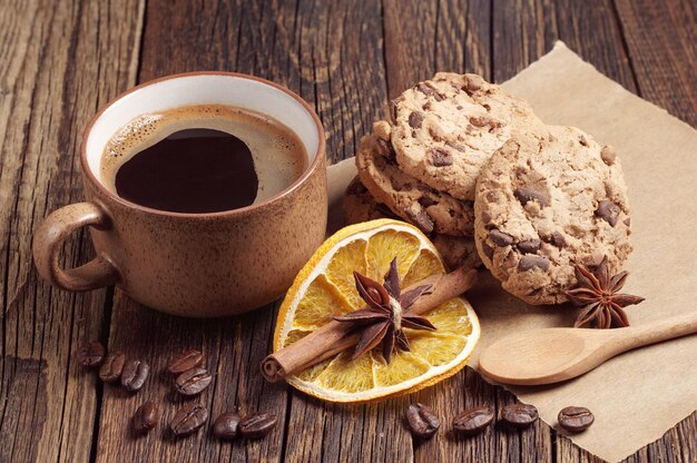 Pyszne ciasteczka i filiżanka gorącej kawy na ciemnym drewnianym stole
