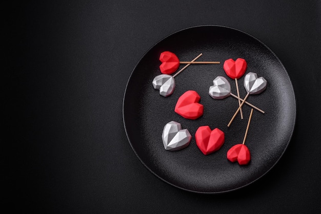 Pyszne cukierki czekoladowe w kształcie serca na ciemnym betonowym tle