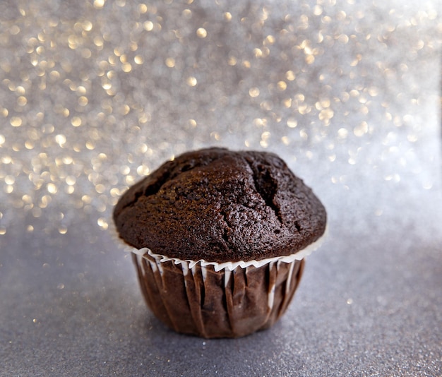 Pyszne czekoladowe muffiny na srebrnym błyszczącym tle
