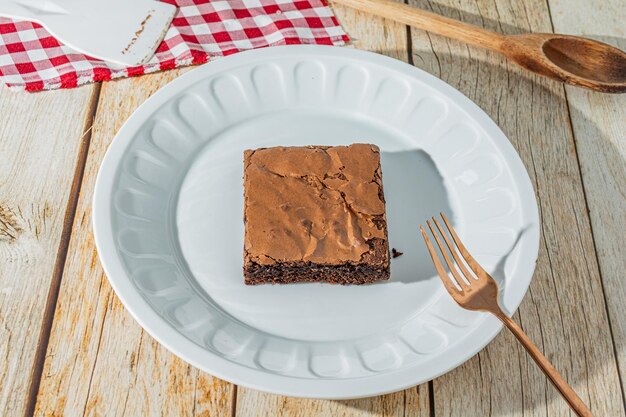 Pyszne domowe ciasto czekoladowe nad stołem z talerzem na widelec smaczny deser czekoladowy