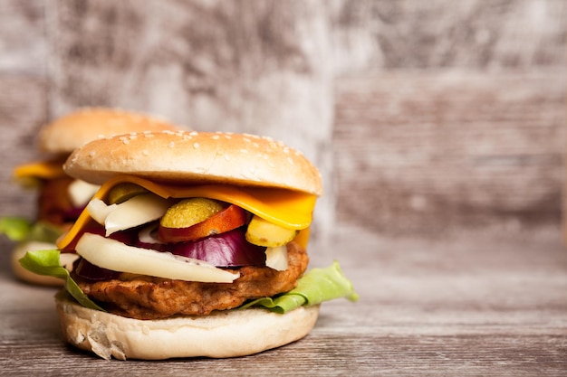 Pyszne domowe hamburgery na drewnianym talerzu. Fast food. Niezdrowa przekąska