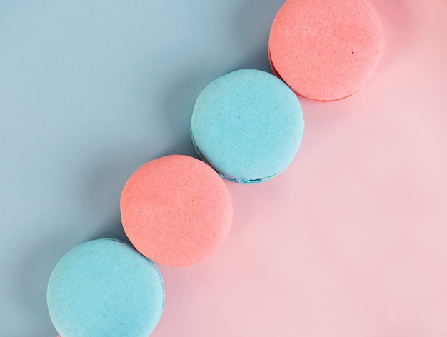 Zdjęcie pyszne kolorowe francuskie ciasteczka makaronów na różowym i niebieskim tle widok z góry selektywny fokus