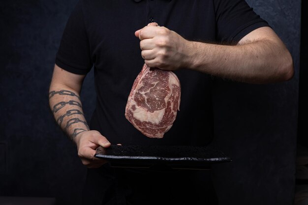 Zdjęcie pyszne marmurkowe mięso na ciemnym tle z bliska