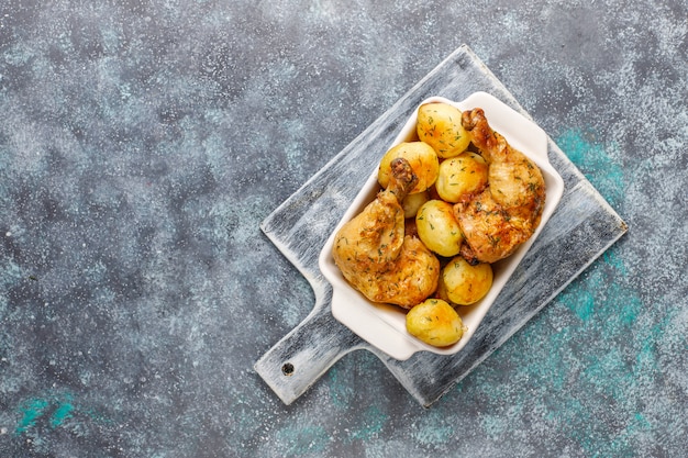 Zdjęcie pyszne pieczone młode ziemniaki z koperkiem i kurczakiem, widok z góry