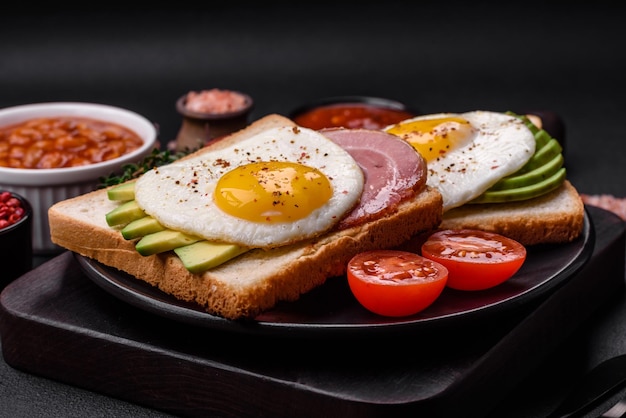 Pyszne pożywne śniadanie angielskie ze smażonymi jajkami, pomidorami i awokado