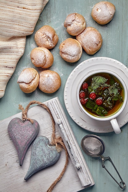 Pyszne profiteroles z bitą śmietaną i dwoma ozdobnymi drewnianymi serduszkami