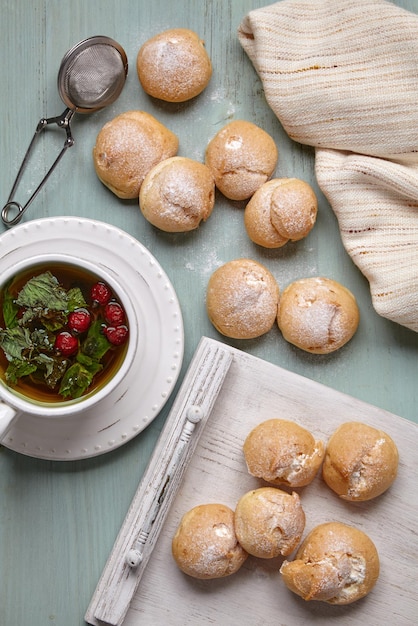 Pyszne profiteroles z bitą śmietaną posypane cukrem pudrem