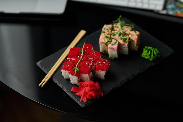Pyszne rolki sushi z łososia wasabi i imbiru na czarnym talerzu