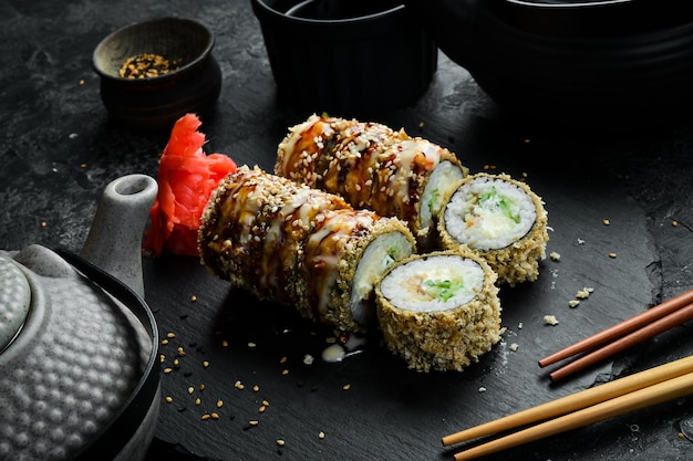 Pyszne rolki sushi z węgorzem Tradycyjne japońskie jedzenie na czarnym kamiennym talerzu