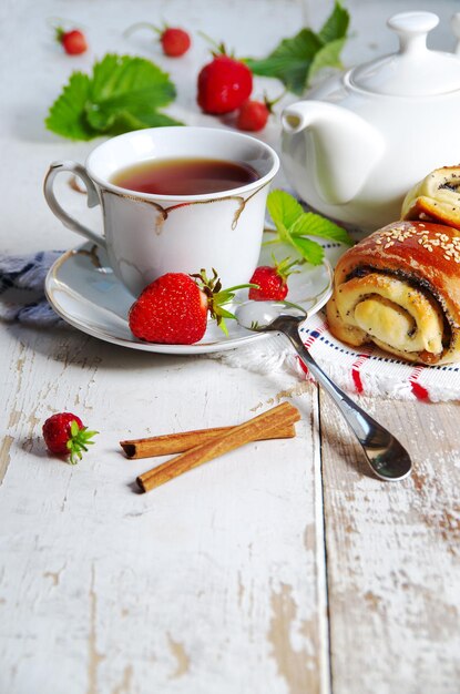 Zdjęcie pyszne śniadanie z herbacianych świeżych bułek z sezamem i truskawkami na tle