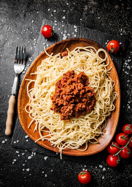 Pyszne spaghetti bolognese w misce z pomidorkami koktajlowymi