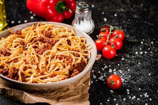 Pyszne spaghetti bolognese w misce z pomidorkami koktajlowymi