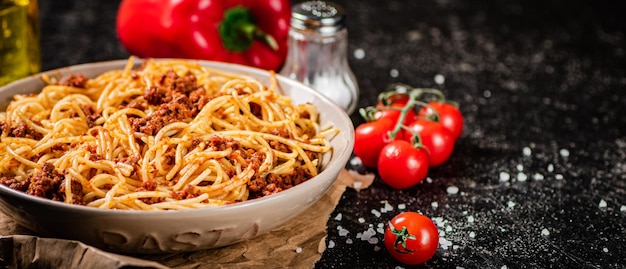 Pyszne spaghetti bolognese w misce z pomidorkami koktajlowymi