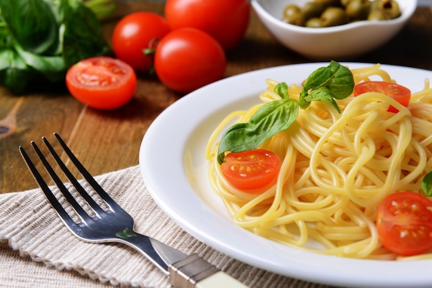 Pyszne spaghetti z pomidorami na talerzu na stole zbliżenie