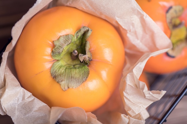 Zdjęcie pyszne świeże pomarańczowe owoce persimmon na drewnianym stole