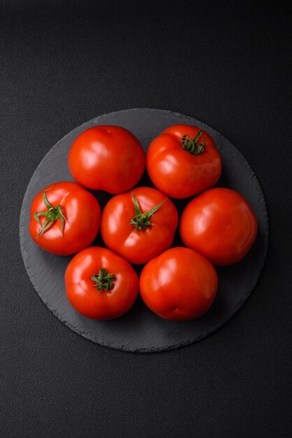 Pyszne świeże soczyste pomidory na ciemnym betonowym tle