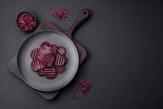Pyszne zdrowe gotowane buraki w kolorze rubinowym pokrojone na czarnym talerzu