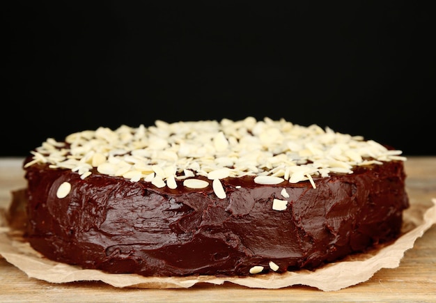 Pyszny ciasto czekoladowe z migdałami na drewnianym stole na ciemnym tle
