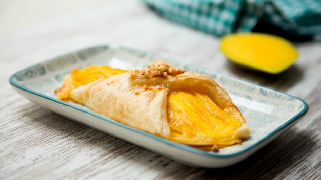 Pyszny francuski deser z ciasta francuskiego nadziewany świeżymi owocami mango.