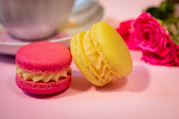 Zdjęcie pyszny francuski makaron deser closeup kolorowe makarony kwiaty i herbata