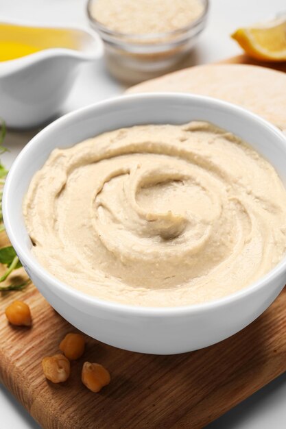 Pyszny hummus i różne składniki na białym stole