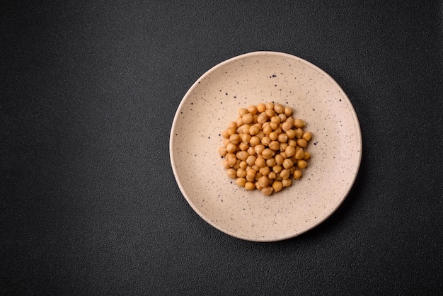 Pyszny konserwowany ciecierzyca na ceramicznym talerzu na ciemnym tle betonowym Składnik potraw wegetariańskich