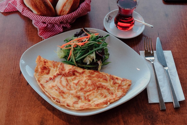 Zdjęcie pyszny omlet i talerz śniadaniowy na stole.