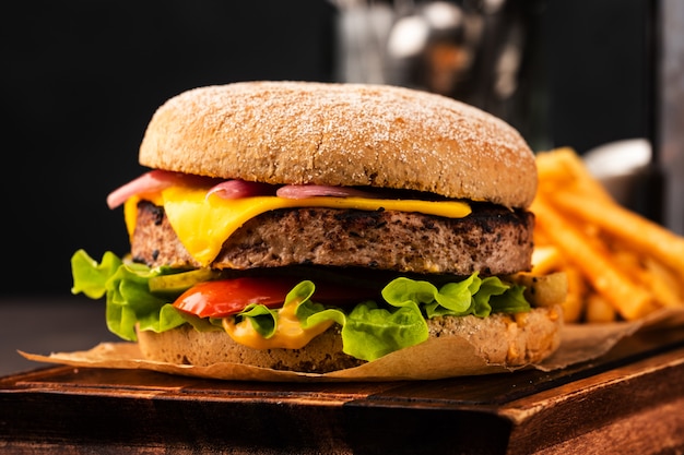 Pyszny świeży domowy cheeseburger z marynowaną cebulą i czerwoną papryką