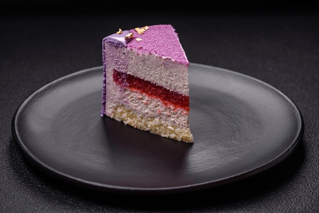 Pyszny świeży słodki ciasto mousse z wypełnieniem jagodowym z różowym aksamitem na ciemnym tle betonowym