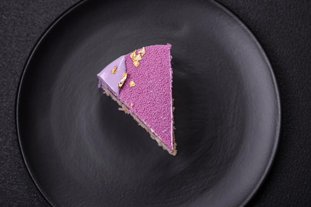 Zdjęcie pyszny świeży słodki ciasto mousse z wypełnieniem jagodowym z różowym aksamitem na ciemnym tle betonowym