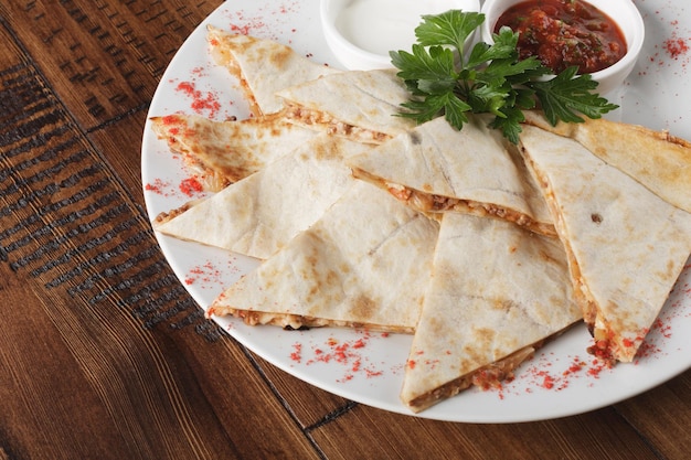 Quesadilla Z Wołowiną I Kurczakiem Na Brązowym Drewnianym Stole. Widok Z Góry. Quesadilla I Sos.