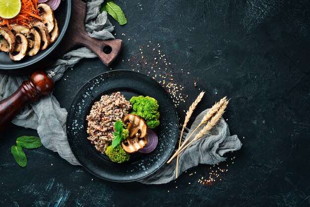 Quinoa z pieczarkami i warzywami na talerzu. Widok z góry. Wolne miejsce na Twój tekst.