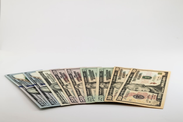 Rachunki pieniężne w dolarach amerykańskich rozłożone na białej ścianie