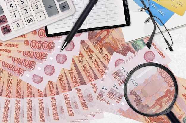 Rachunki za 5000 rubli rosyjskich i kalkulator z okularami i długopisem
